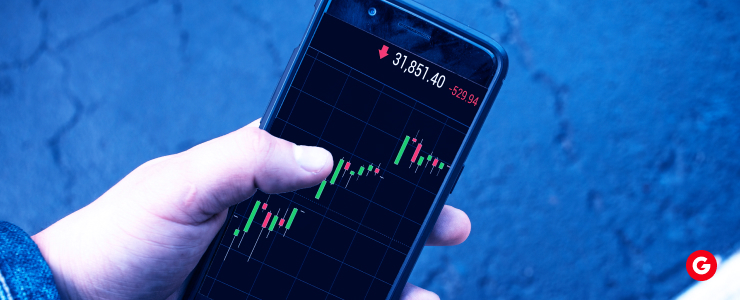 A person holding a smartphone displaying a stock chart, illustrating financial data and market trends.