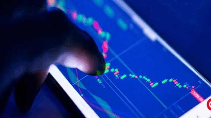 A person examines a stock market chart on a tablet, analyzing financial trends and data.