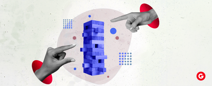 Two hands pointing towards a blue block featuring a prominent red dot on its surface.